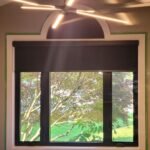 Blackout roller shade over tall glass patio doors