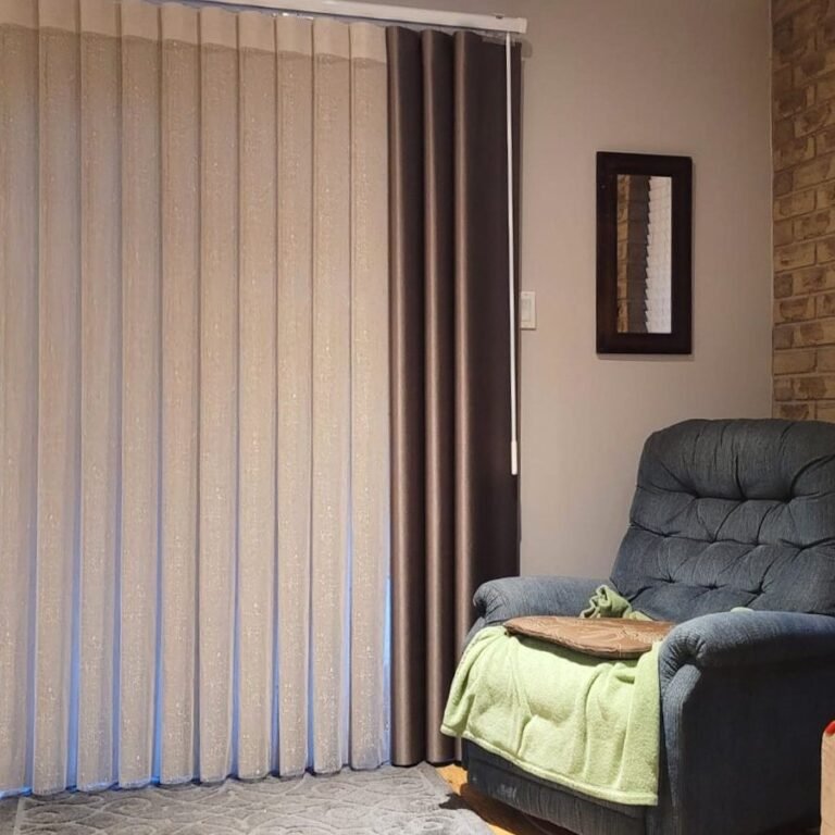 Sheer curtains with drapery panels beside a recliner