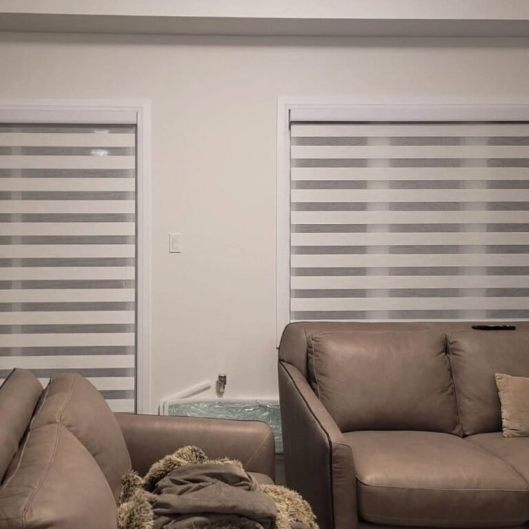 Light grey zebra blinds in a living room with grey sofas
