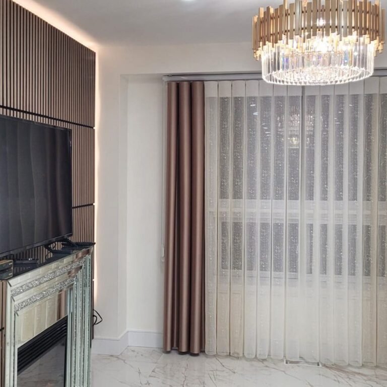 Sheer curtains with drapery panels in a living room with a chandelier