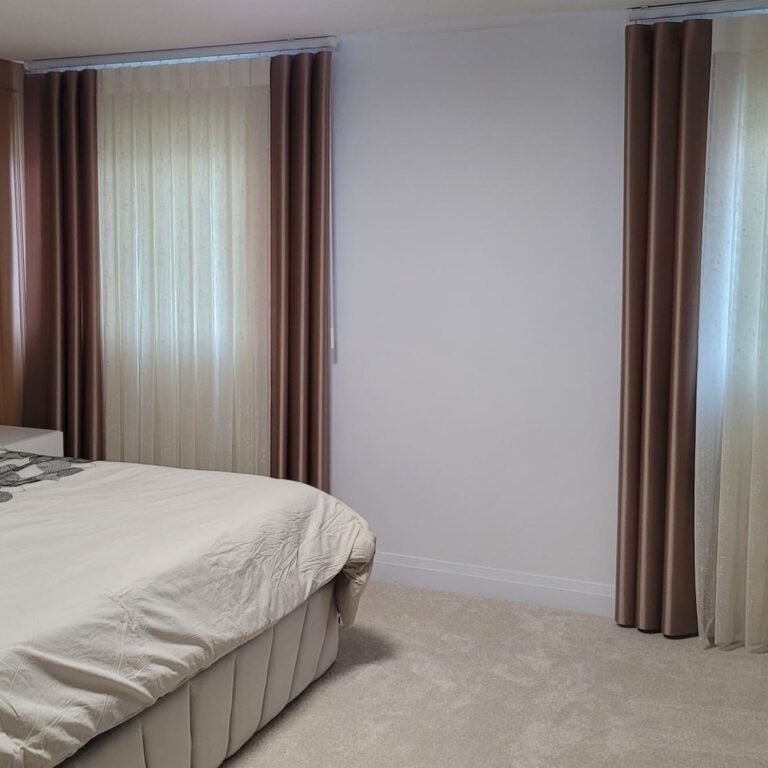 Neutral drapery panels beside a bed