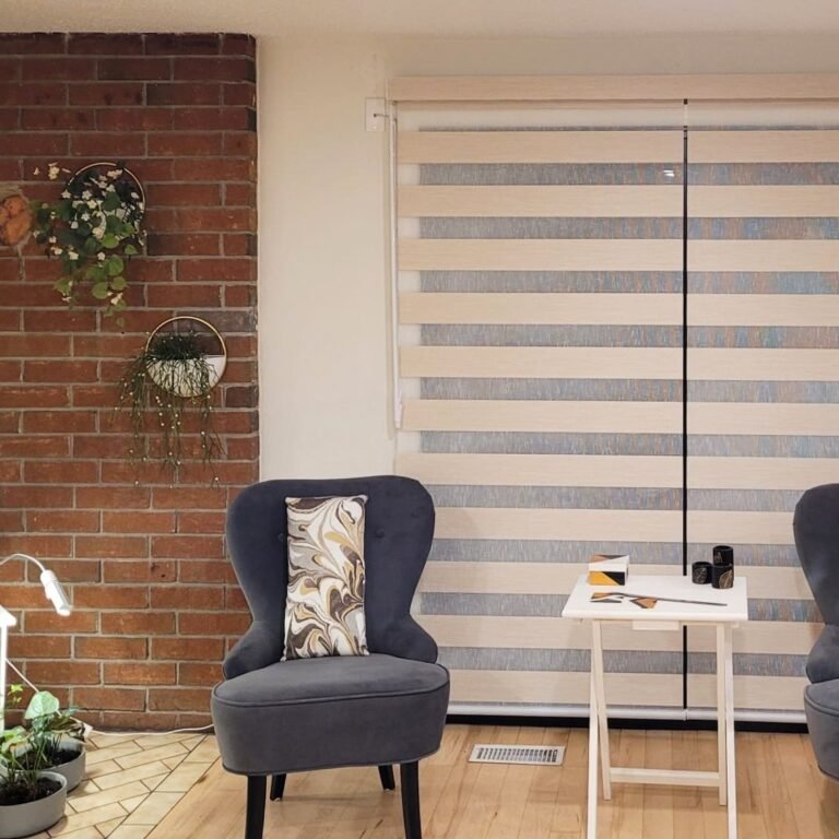 White zebra blinds beside a brick wall and reading chair
