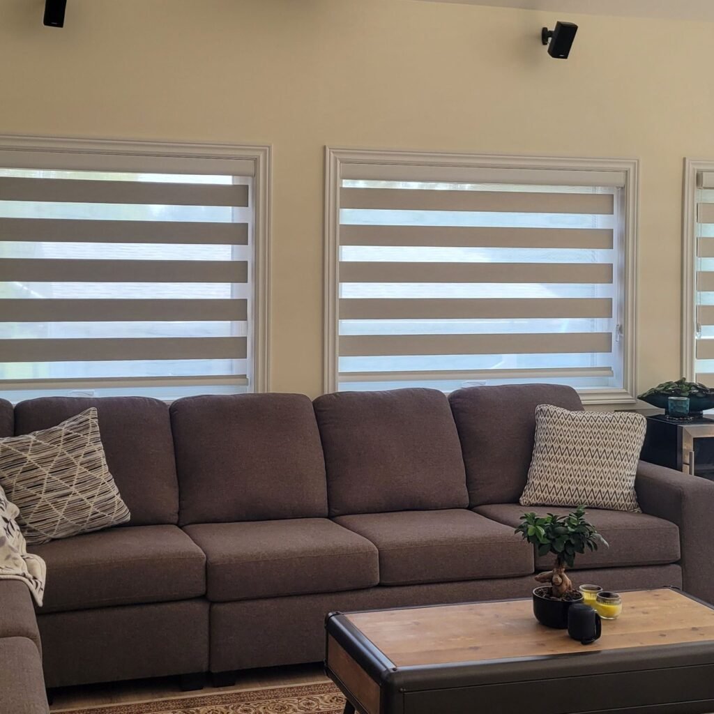 Zebra blinds on family room windows above a sectional sofa