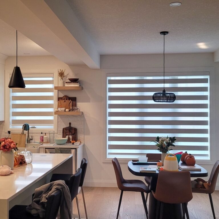 Zebra blinds on windows in an open kitchen and dining area