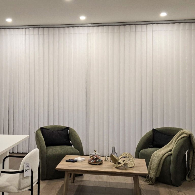 Vertical sheers behind two armchairs in a sitting area