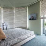 Motorized shades on corner windows in a bedroom
