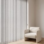 Soft vertical sheers on a tall window beside an armchair
