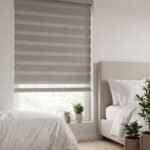 Grey zebra blind above a bed in a bright bedroom